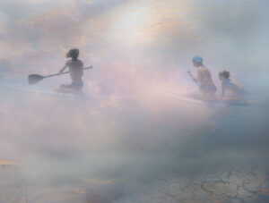 surfers rowing in mist