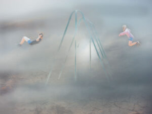 two people on swings misty background