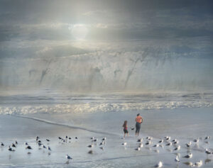 two children on beach with iceberg in the background and many birds near the children