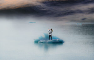 girl stands on iceberg with iphone